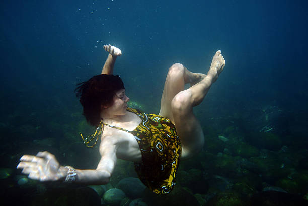 Young Woman Drifting Underwater in Ocean stock photo
