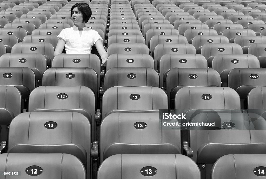 Mujer sentada solo en el estadio sillas, blanco y negro - Foto de stock de Sentado libre de derechos