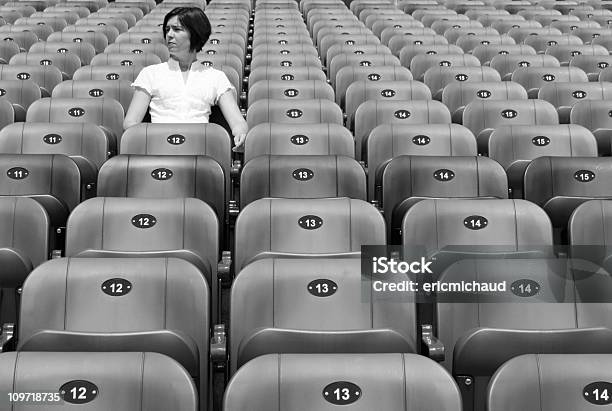 Mujer Sentada Solo En El Estadio Sillas Blanco Y Negro Foto de stock y más banco de imágenes de Sentado