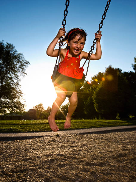 istock Cute Little Girl Laughing While Swinging at Playground 109718746