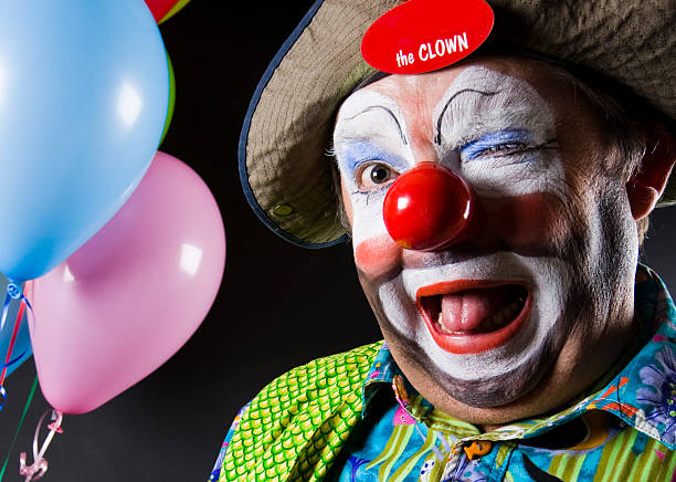 coloré clown faire un clin d'oeil à la caméra - clown photos et images de collection