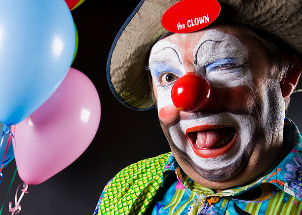 kolorowe clown puszczać oko na kamerze - clown zdjęcia i obrazy z banku zdjęć