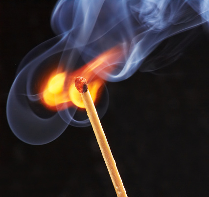 Lit smoking incense stick on black background. Aromatherapy.