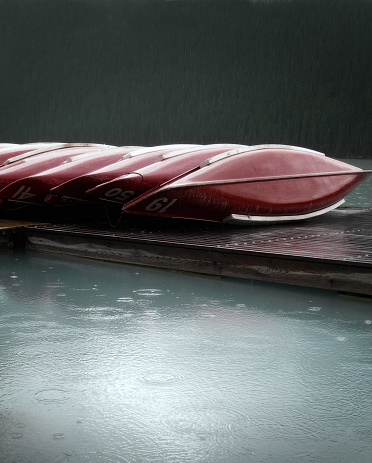 Row of canoes on Lake Louise in the rain