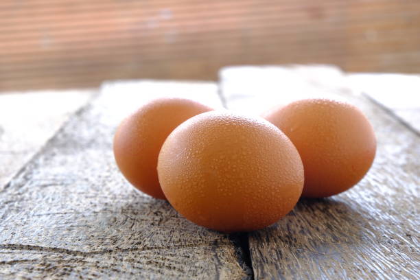 istock Chicken eggs on old wooden background. 1097194530