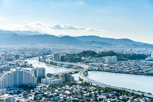 Asia Business concept for real estate and corporate construction - panoramic urban townscape aerial view under bright blue sky and sun in Fukuoka Japan