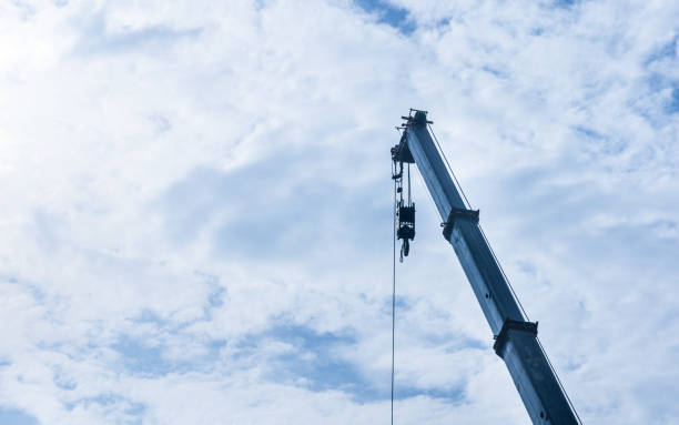 istock hoist crane hook head with blue sky cloud background 1097196114