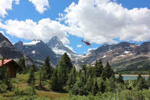 Mount Assiniboine Helicopter flying near Mount Assiniboine and Lake Magog in Mount Assiniboine Provincial Park British Columbia Canada on a bright sunny day. lake magog photos stock pictures, royalty-free photos & images