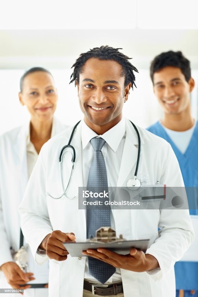 African American médico con colegas en la parte posterior - Foto de stock de Doctor libre de derechos