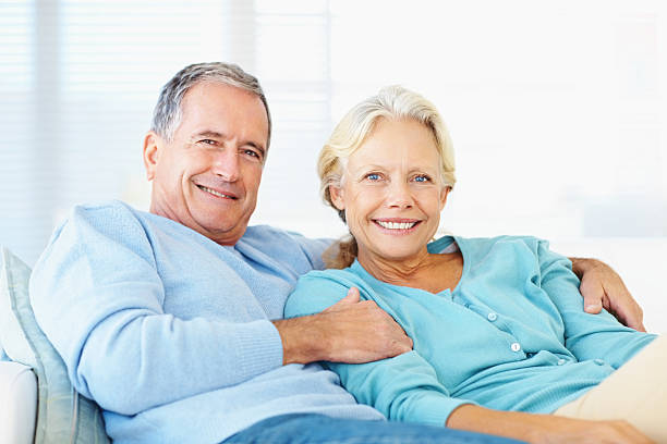istock Smiling retired couple sitting on couch at home 109720356