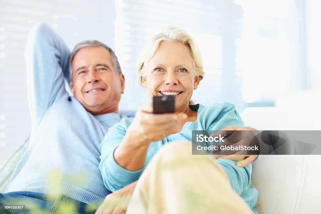 Happy retired couple watching TV at home  Senior Adult Stock Photo