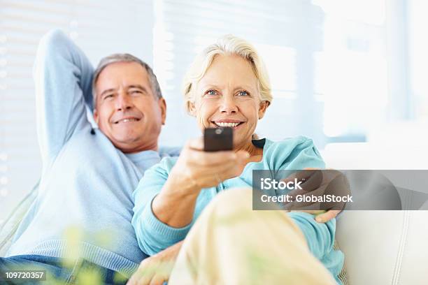 Happy Retired Couple Watching Tv At Home Stock Photo - Download Image Now - Senior Adult, Television Set, Watching TV