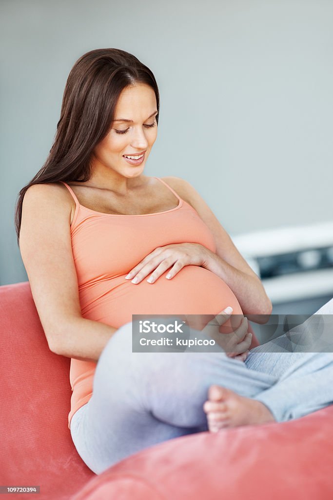 Sorridente jovem fêmea grávida sentada num sofá - Royalty-free 25-29 Anos Foto de stock