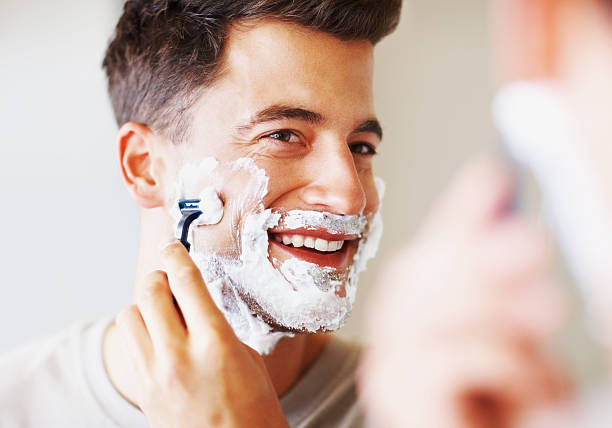 glückliche mittleren alter mann mit rasierbrand zu rasieren - razor stock-fotos und bilder