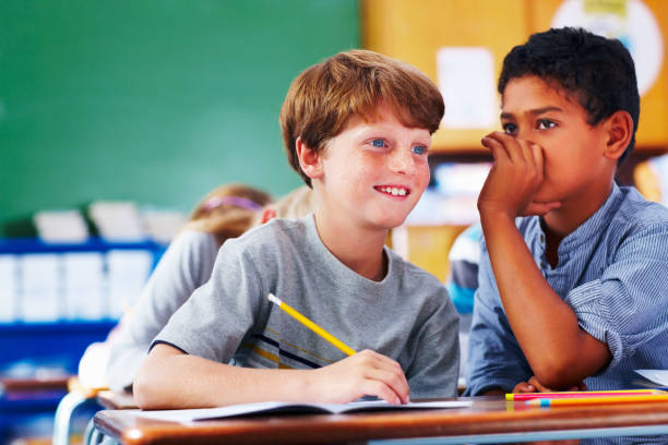 istock Schoolboy sharing a secret with his friend 109720572