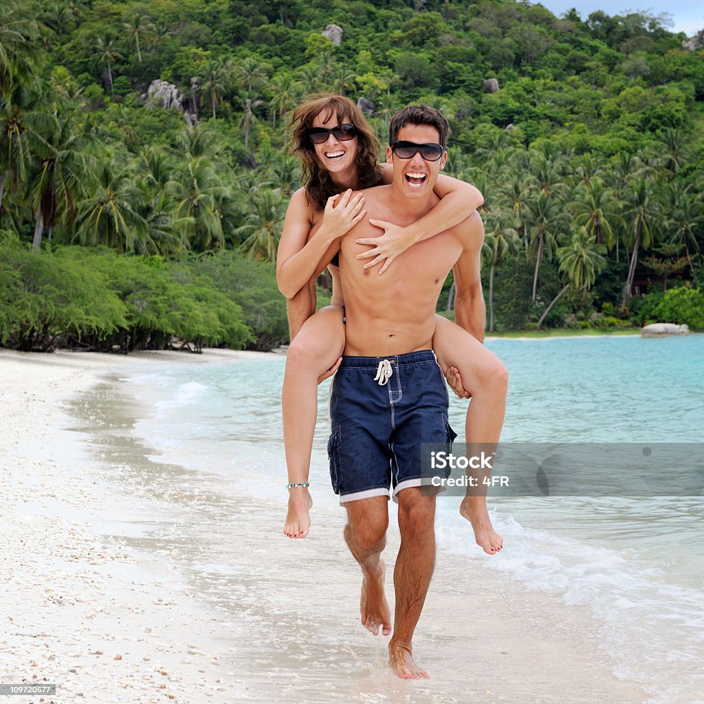 Casal correndo-se um paraíso de palmeiras da praia de Costa (XXXL - Foto de stock de 20 Anos royalty-free