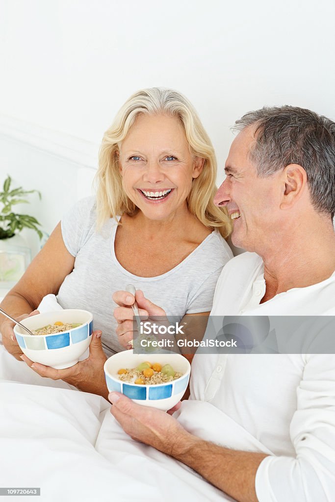 Sorridente Casal Aposentado tendo o pequeno-almoço na cama - Royalty-free 55-59 anos Foto de stock