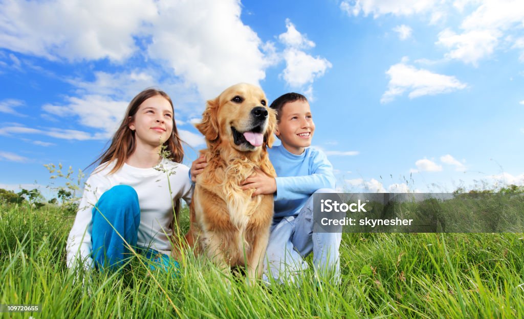 Crianças com cão ao ar livre, sentada na relva verde. - Royalty-free Amizade Foto de stock