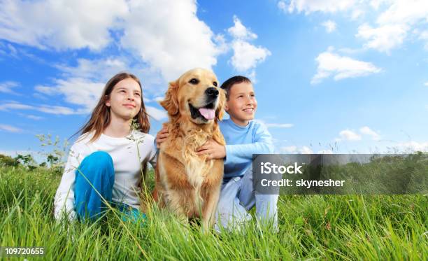 Crianças Com Cão Ao Ar Livre Sentada Na Relva Verde - Fotografias de stock e mais imagens de Amizade