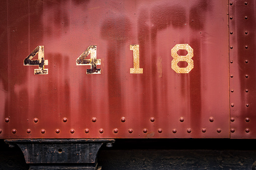 Chipped, faded, rusty painted numbers on the side of a train car
