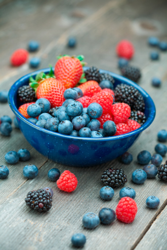 Blackberry granola yogurt dessert with berris and mint leaf on wooden cut borad on white background, copy space,