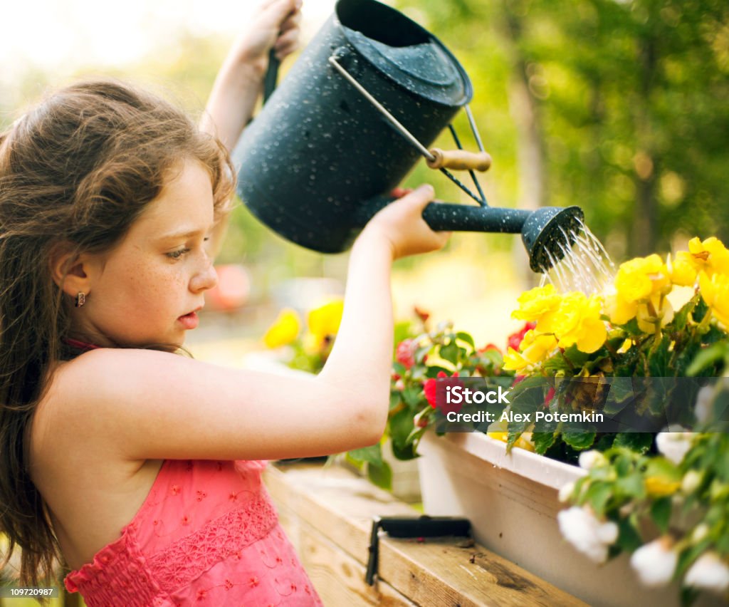 Femme arroser les fleurs - Photo de Enfant libre de droits