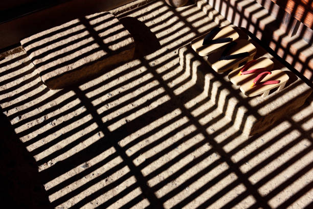 High angle view of light and shadows of old Japanese entrance with clogs.