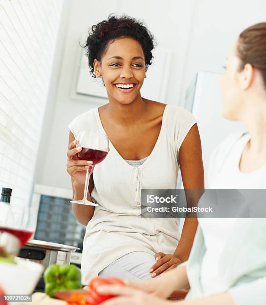 Sorridenti Giovani Amici Avendo Una Chat Durante La Preparazione Di Alimenti - Fotografie stock e altre immagini di 20-24 anni