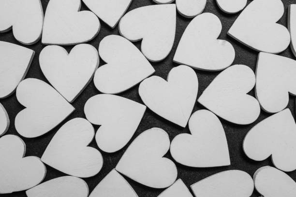 White wooden hearts on black background. Valentines pattern. stock photo