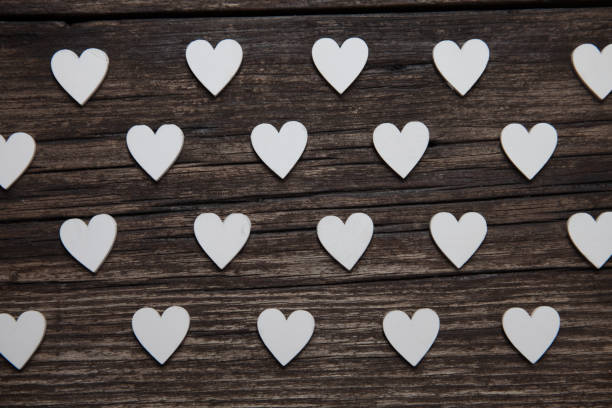 Valentines day card. A white hearts on old wooden background. Valentines pattern. stock photo