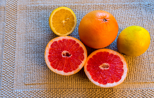 Citrus grapefruit and patterns of its cut, all on gray color cloth.