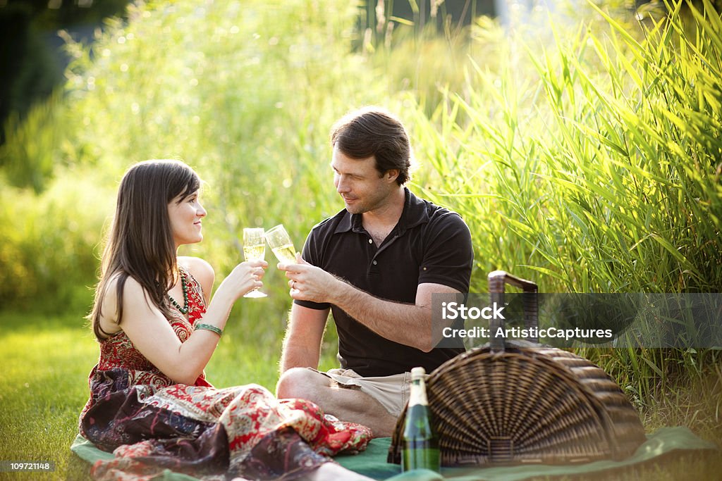 Romantyczna para cieszyć się piknik poza z do wina - Zbiór zdjęć royalty-free (20-29 lat)