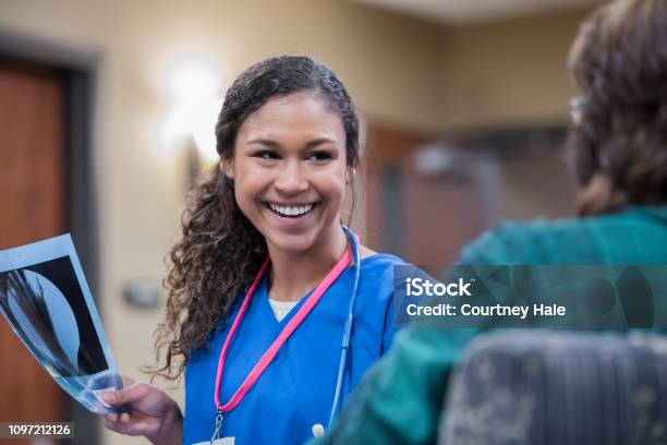 Radiologist Or Nurse Smiles While Discussing Xray With Patient In Clinic Stock Photo - Download Image Now