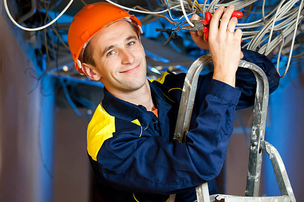Construction repairman on stepladder Construction repairman with a combination pliers on a stepladder electrician smiling stock pictures, royalty-free photos & images