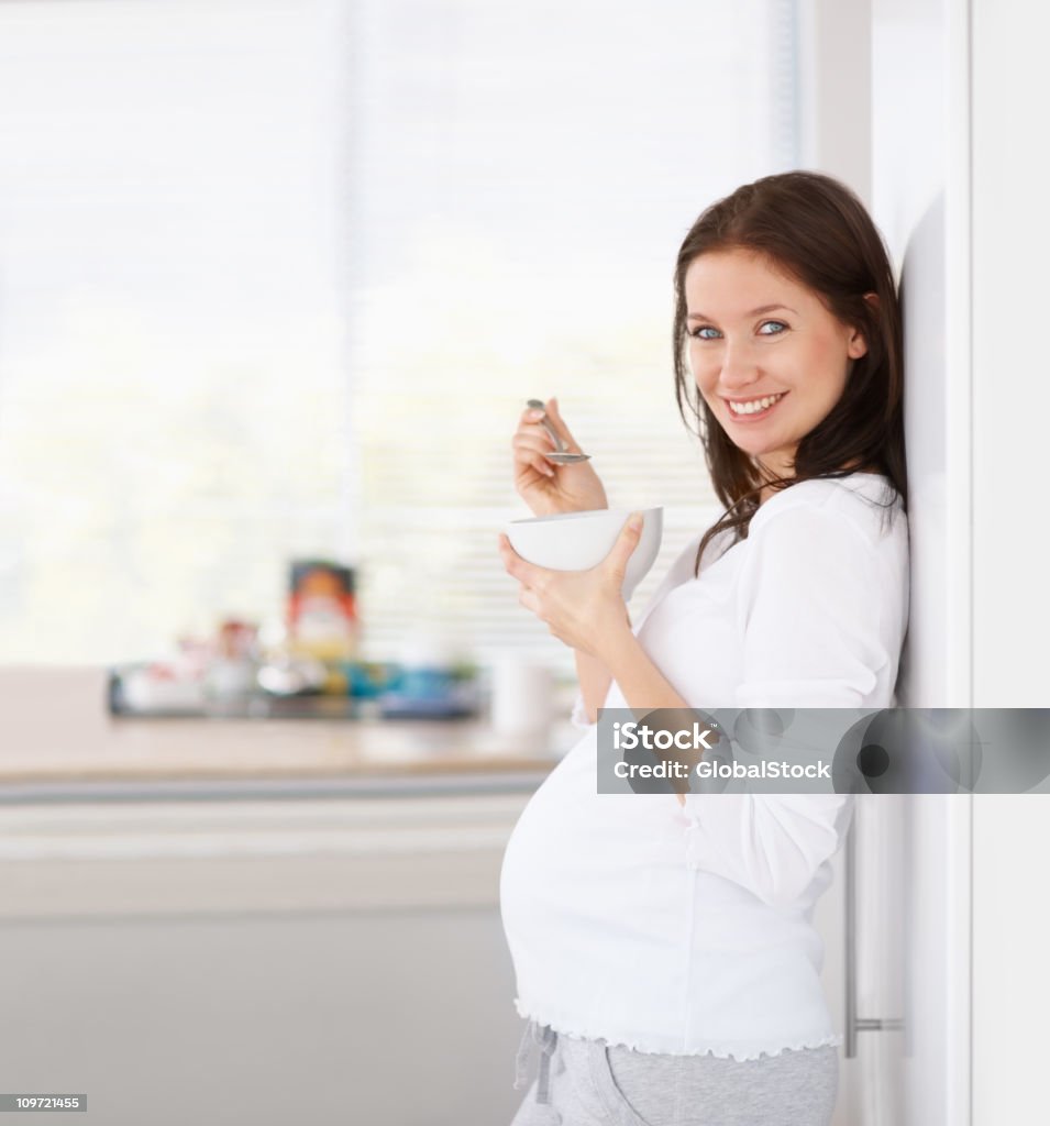 Schöne schwangere Frau, die eine Schale Müsli - Lizenzfrei 20-24 Jahre Stock-Foto