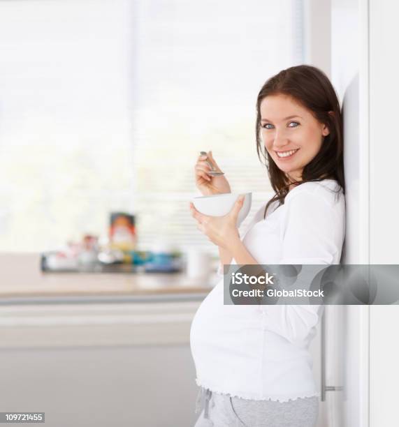 Schöne Schwangere Frau Die Eine Schale Müsli Stockfoto und mehr Bilder von 20-24 Jahre - 20-24 Jahre, Abwarten, Attraktive Frau