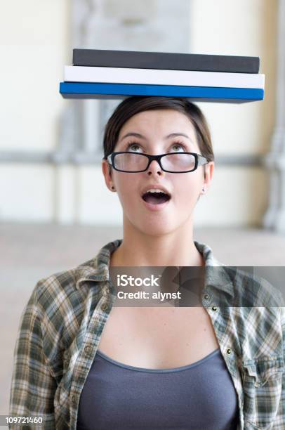 Estudiante Mujer Mirando Sorprendido Contabilización De Los Libros De Texto Sobre La Cabeza Foto de stock y más banco de imágenes de 18-19 años
