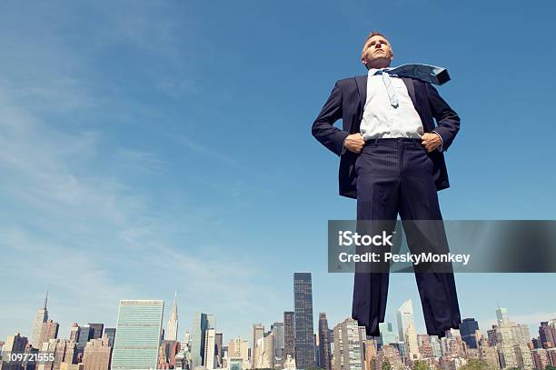 Seguro Gigante De Hombre De Negocios De Pie Alto Con Vista A La Ciudad Foto de stock y más banco de imágenes de Gigante - Ser mítico