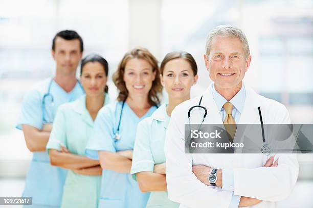 Lekarze Z Rękami Składany Stojące W Rzędzie W Szpitalu - zdjęcia stockowe i więcej obrazów Lekarz