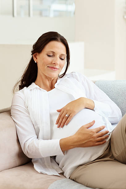 istock Smiling pregnant lady relaxing on couch 109721635