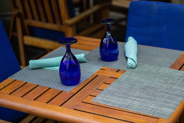 istock Outside Table for two with blue cushion chairs, wooden table and two blue glasses 1097216736