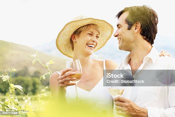 Pareja Disfrutando De Vino En Una Vineyard Foto de stock y más banco de imágenes de 30-39 años - 30-39 años, 35-39 años, 40-44 años