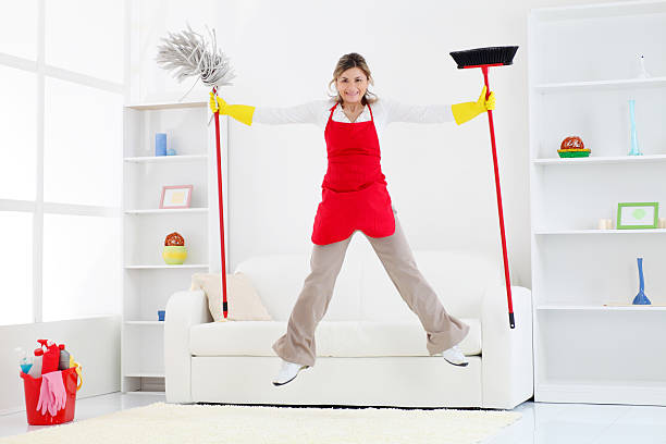 Waist up of aged 20-29 years old who is beautiful with black hair latin american and hispanic ethnicity young women cleaner bending in front of white background wearing apron who is imagination who is doing chores and holding guitar