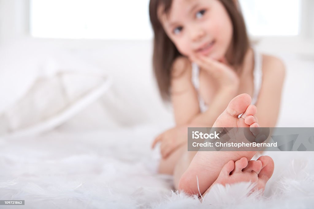 Souriant Petite fille jouant avec des plumes en lit - Photo de 4-5 ans libre de droits