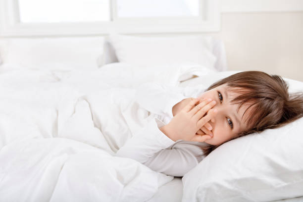 Little toddler girl lying down a on the foot of the bed