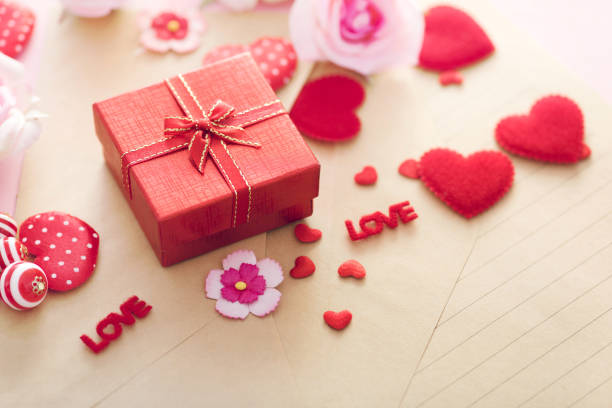 Valentine Day gift box with red hearts and roses on letter envelope.