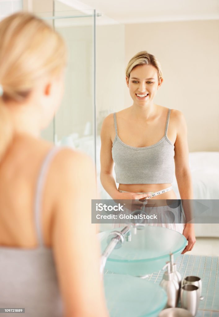 Young female measuring her waist  20-24 Years Stock Photo