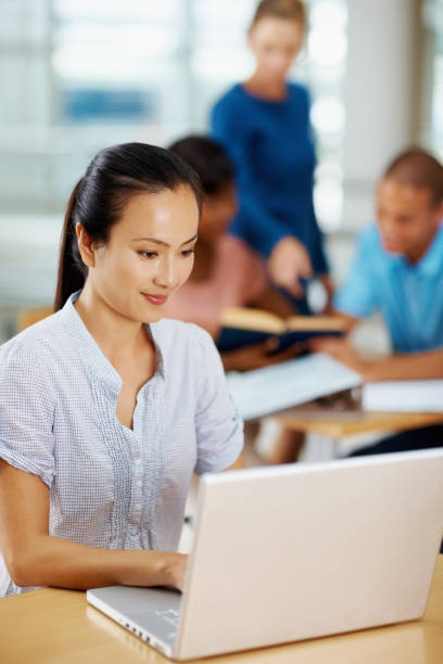 istock Young woman using laptop with friends in back 109722266