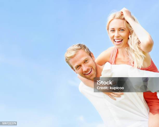 Foto de Homem Romântico Feliz Carregando Mulher De Costas Contra O Céu e mais fotos de stock de 20 Anos