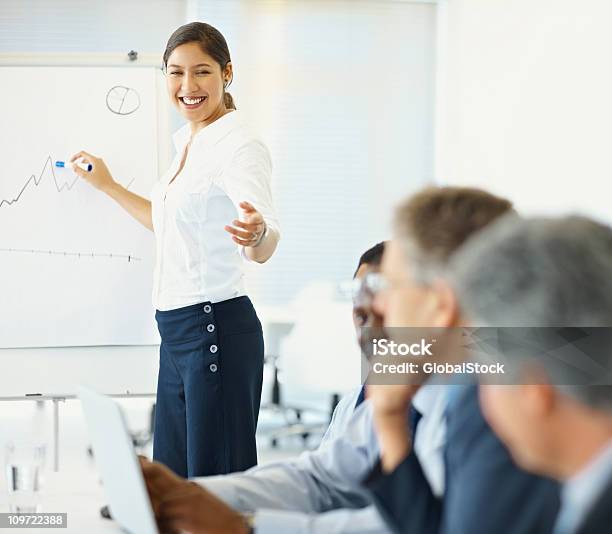 Mujer Sonriente Dando Presentación A Un Grupo De Negocios Foto de stock y más banco de imágenes de 20 a 29 años